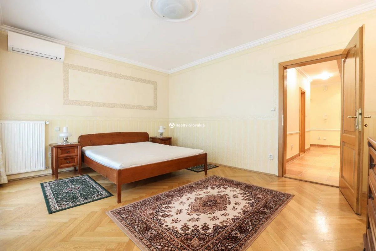 Спальня с деревянной кроватью и ковром — 4-к квартира, аренда, Братислава