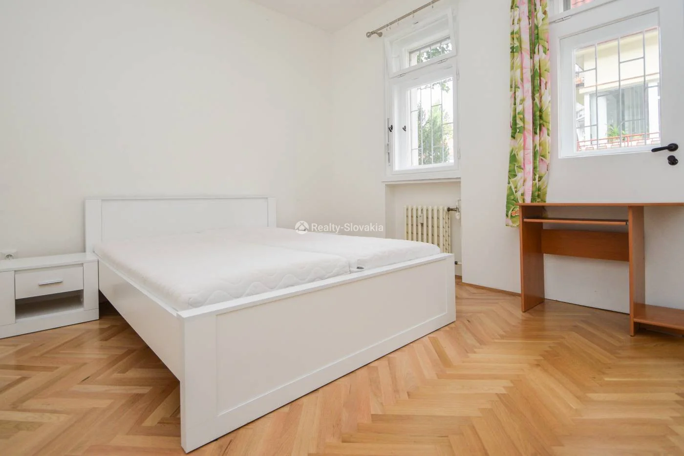Спальня с белой кроватью и письменным столом — 3-к квартира, аренда, Братислава