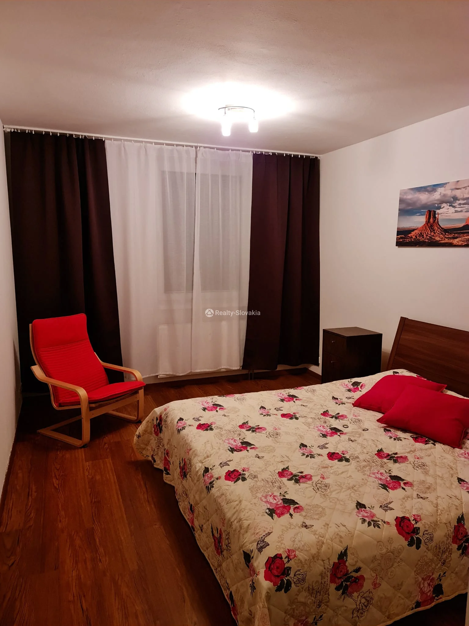 Спальня с кроватью и красным креслом — 2-к квартира, аренда, Братислава