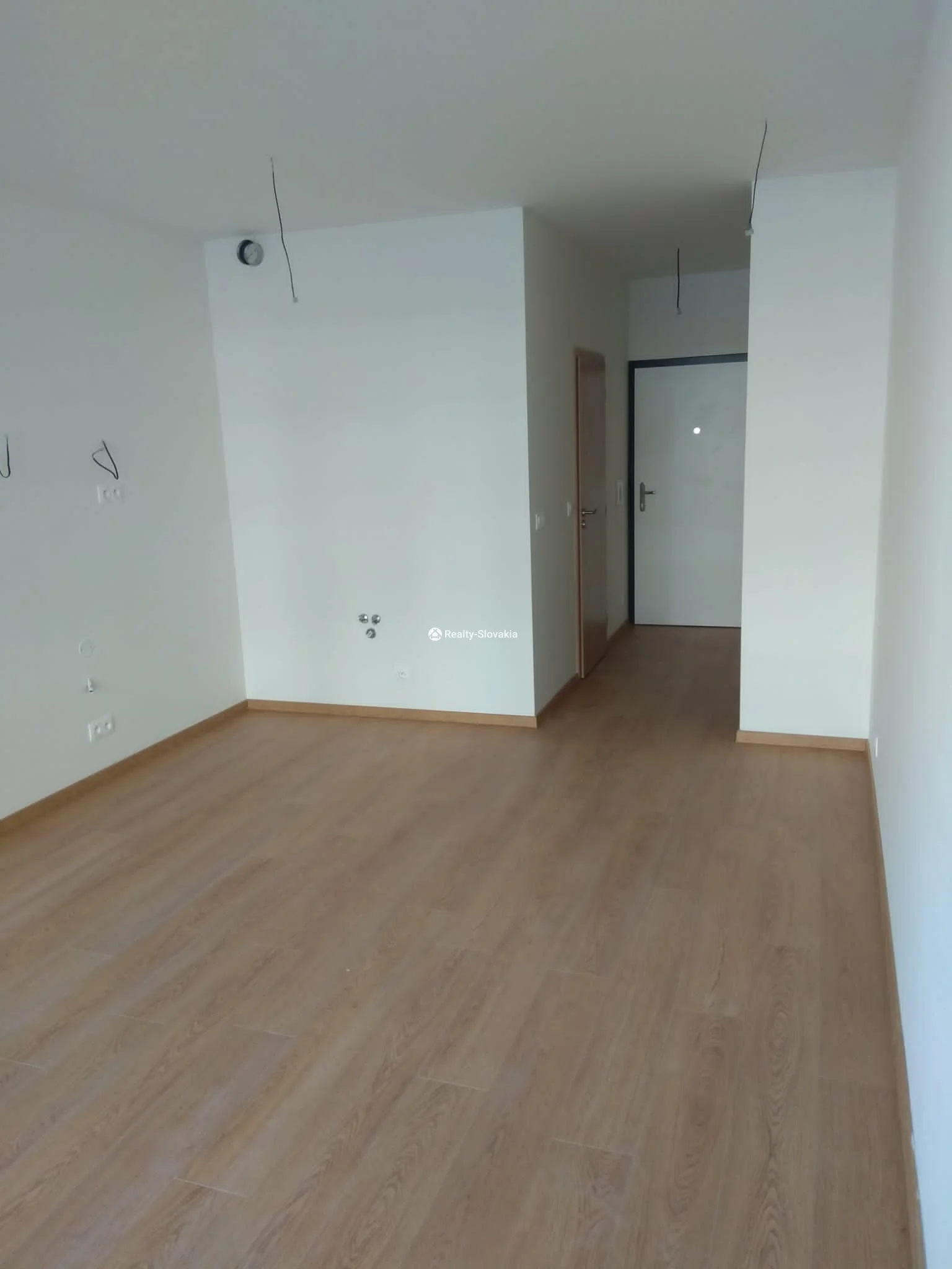 Пустая комната с ламинатом и дверью — 1-к квартира, продажа, Братислава