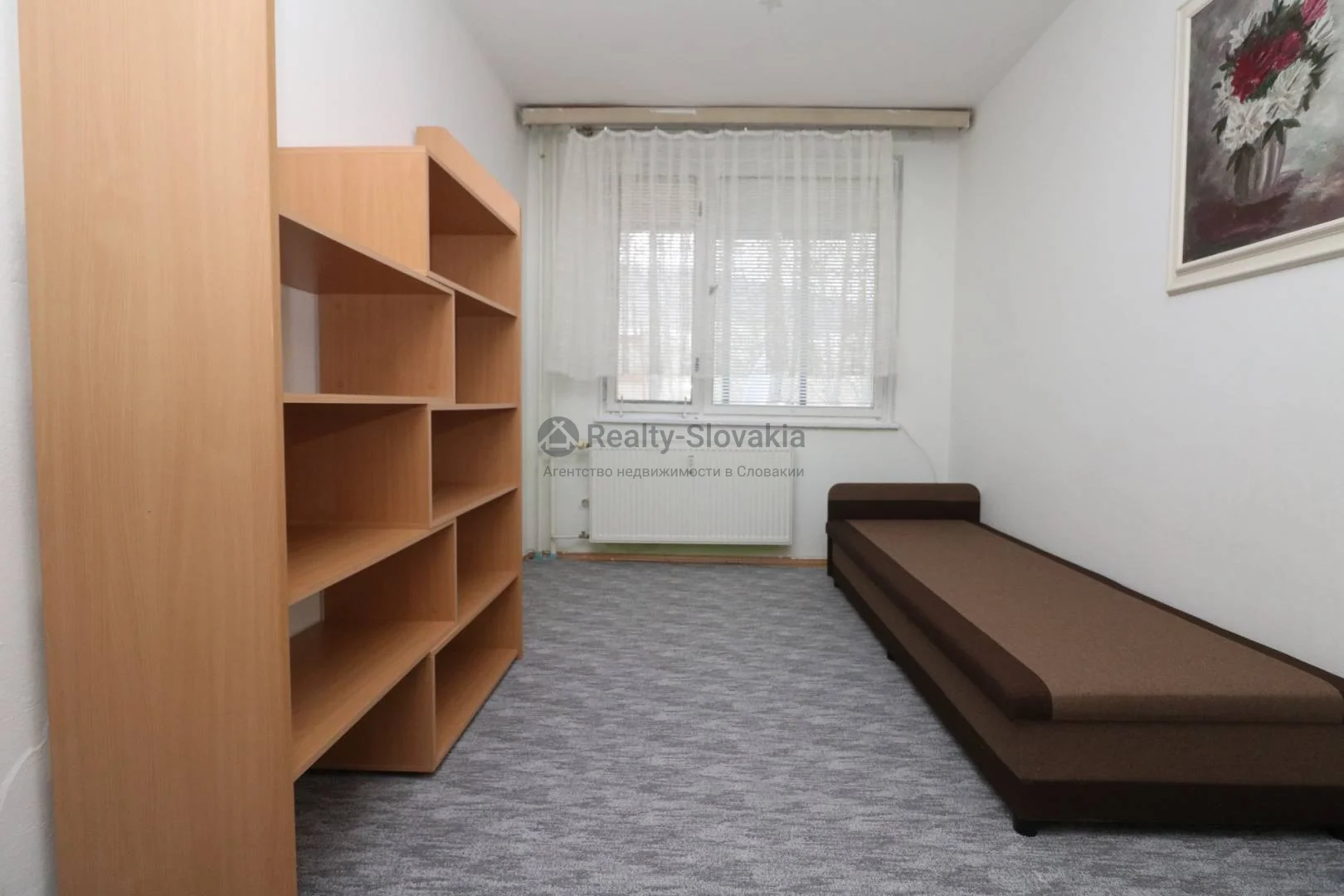 Комната с книжным шкафом и диваном — 4-к квартира, аренда, Братислава