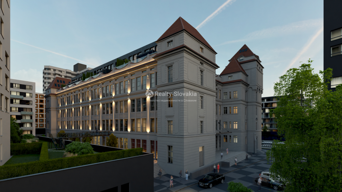 Проект Danubius Lofts: Старое здание рядом с высокой тёмной башней в вечернем свете